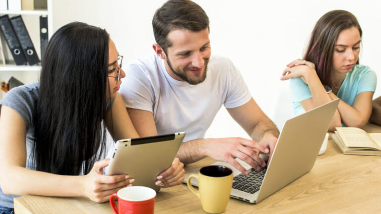 pessoas com notebook tablet e livro em ambiente descontraído com seus cafés.